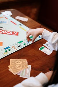 Monopoly Board Game on Brown Wooden Table