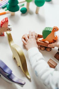 Person Holding Brown Wooden Animal Figurine